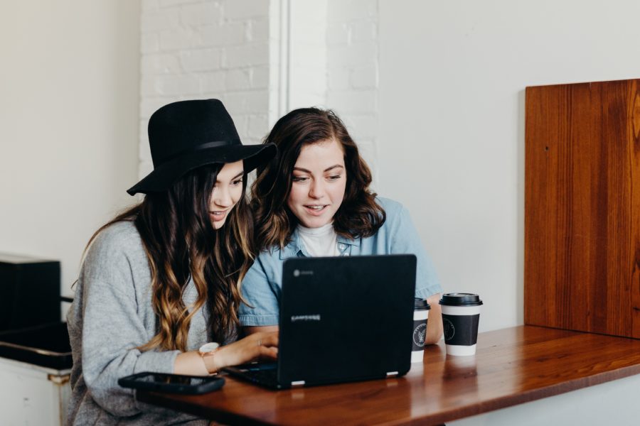 A picture featuring two girls looking at a laptop